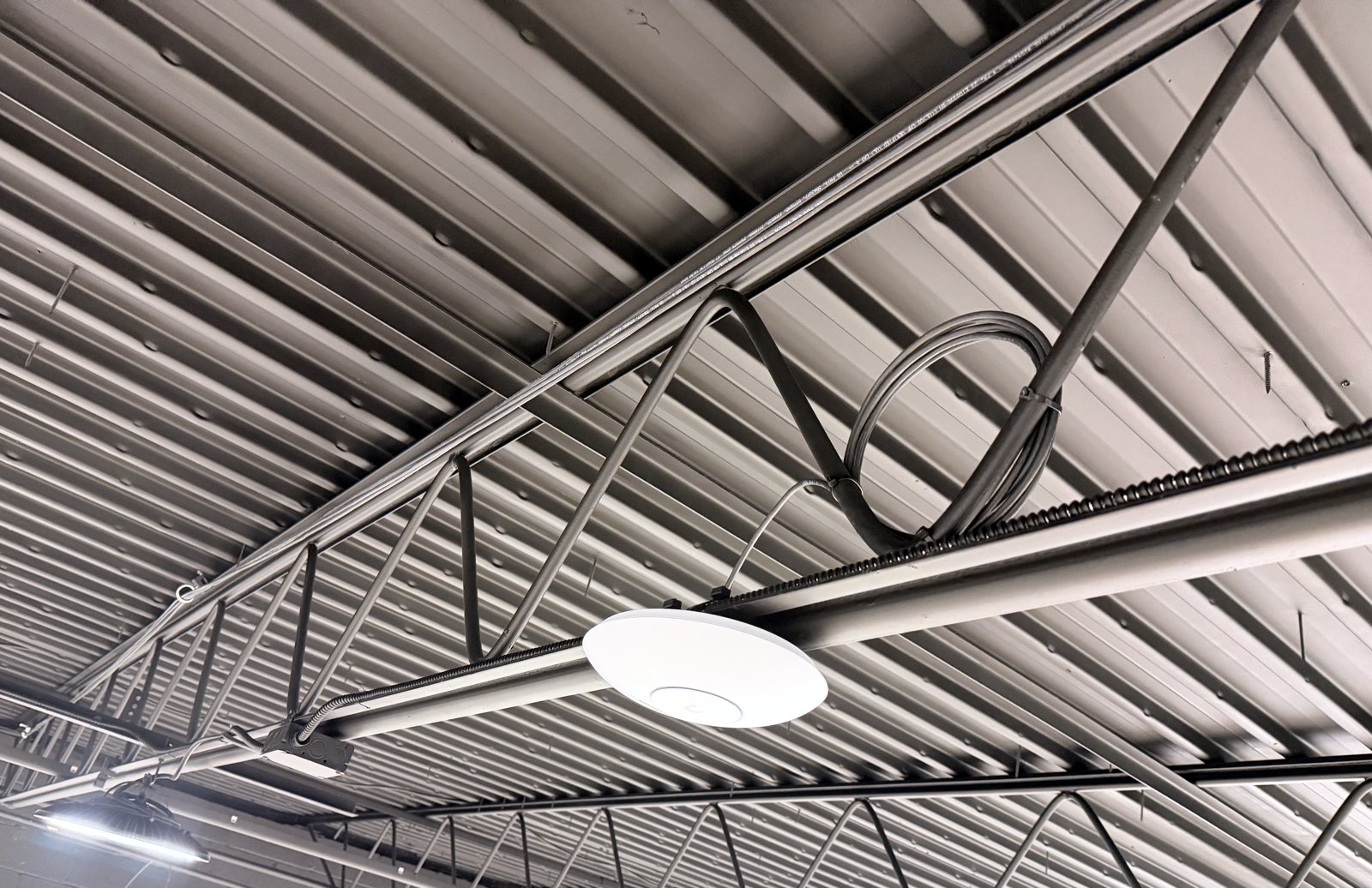 Access point mounted on a steel bar joist with a neat service loop